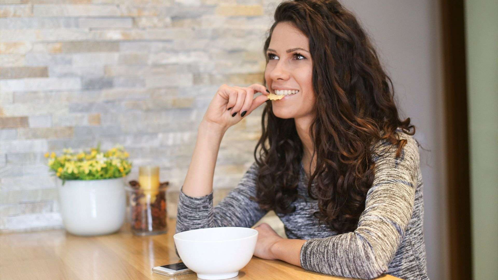 A woman snacking at her desk at work.